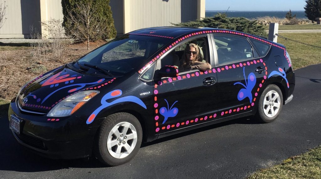 Woman in Black Prius with colorful decals. She was the decal designer and installer
