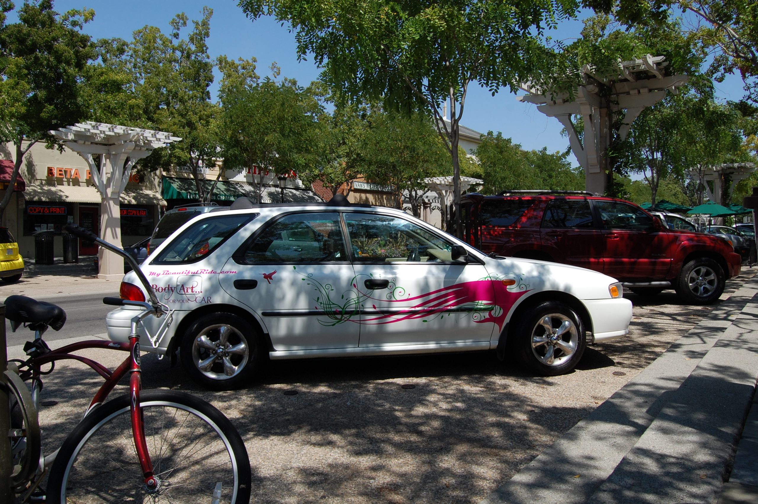 White Subaru body art for your car & hummingbird with pink green decals red bike in foreground